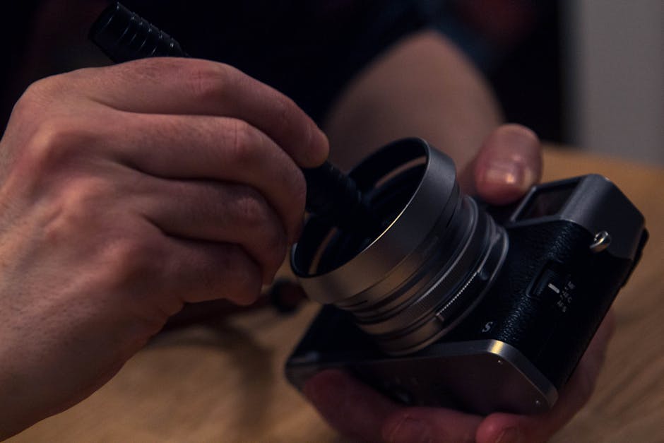 Antika fotoğraf makinesinin ön yüzünü nazikçe temizleyen kişi görüntüsü