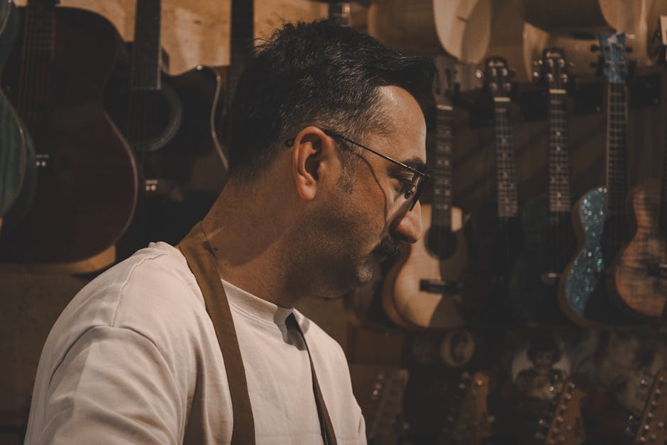 Evde ahşap ukulele yapımı için tahta kesimi yapan zanaatkarın yakın plan görüntüsü
